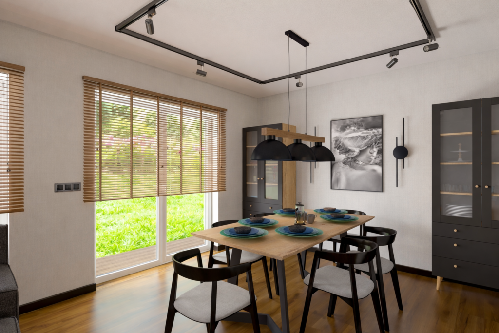 Nowoczesna jadalnia z drewnianym stołem, czarnymi krzesłami i wiszącą lampą nad stołem. Pomieszczenie ma duże okna z drewnianymi żaluzjami, ciemną zabudowę kuchenną po prawej stronie i jasne ściany z obrazem.